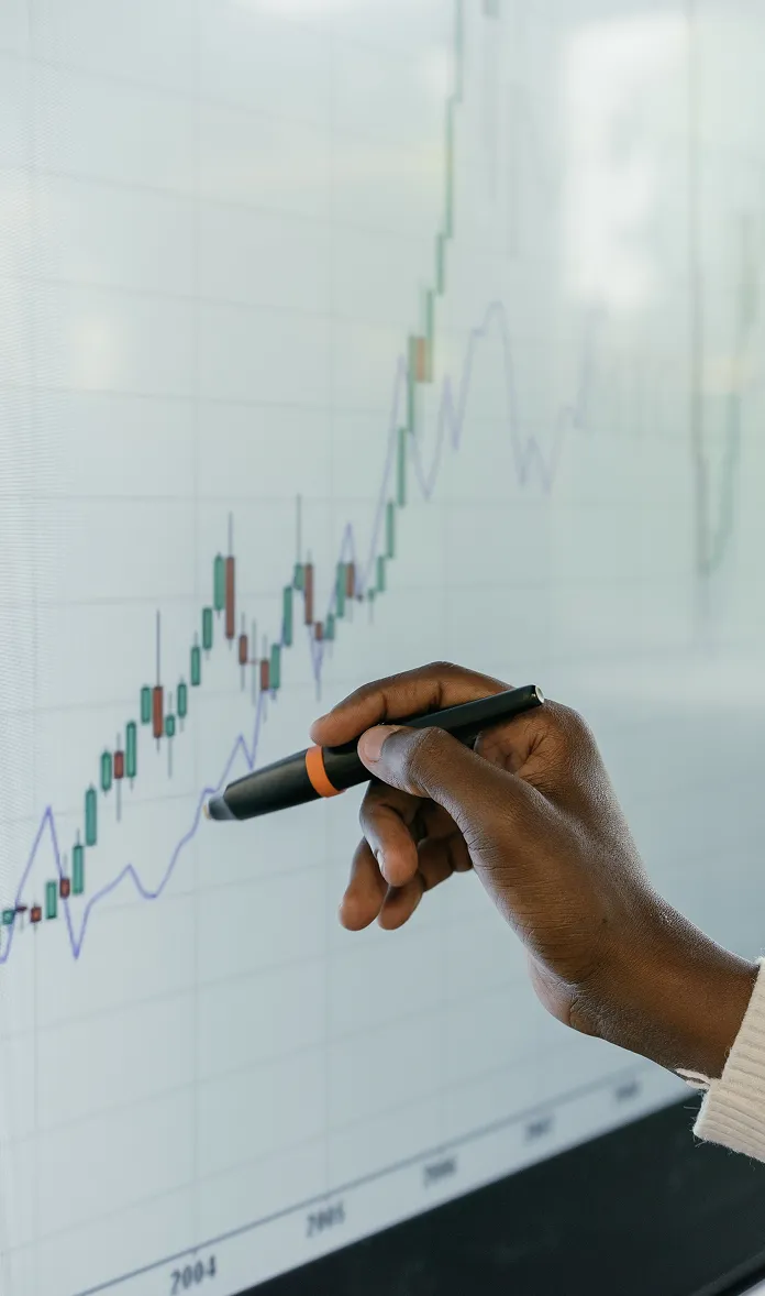 يد تشير إلى مخطط مالي على شاشة رقمية
